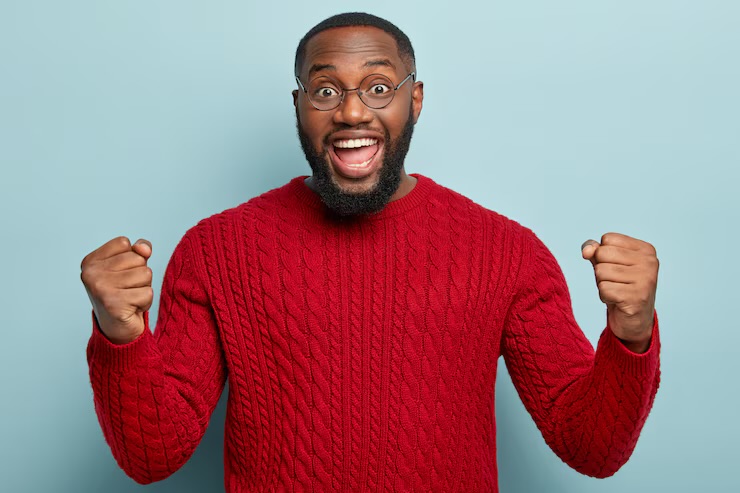 A young man celebrating with both fists raised