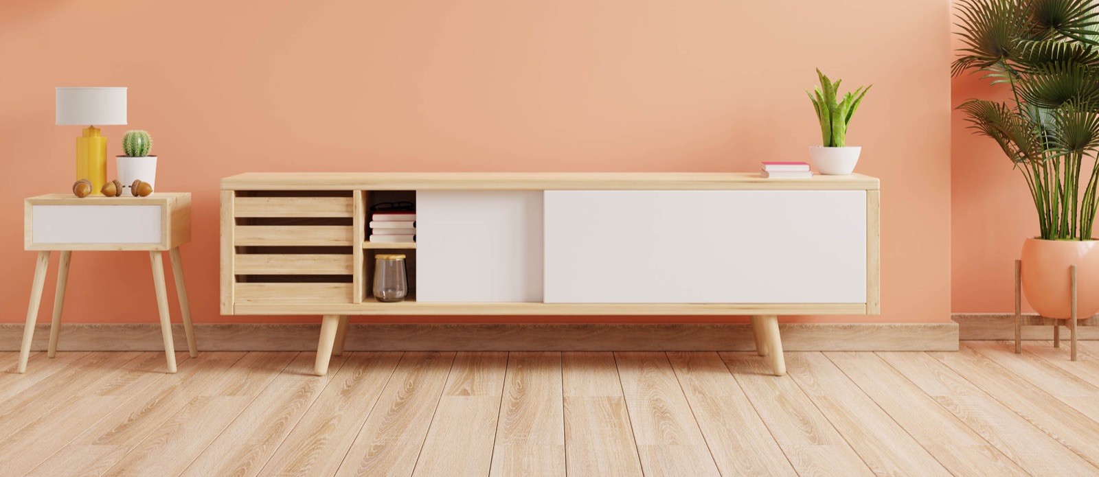 A bright, freshly painted room with a sideboard and a plant
